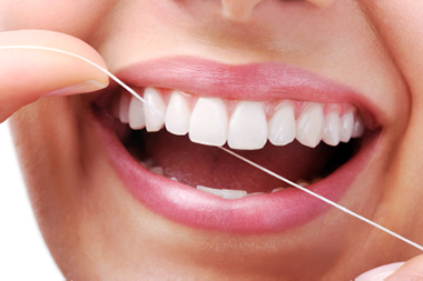 A beautiful, healthy smile being maintained with dental floss